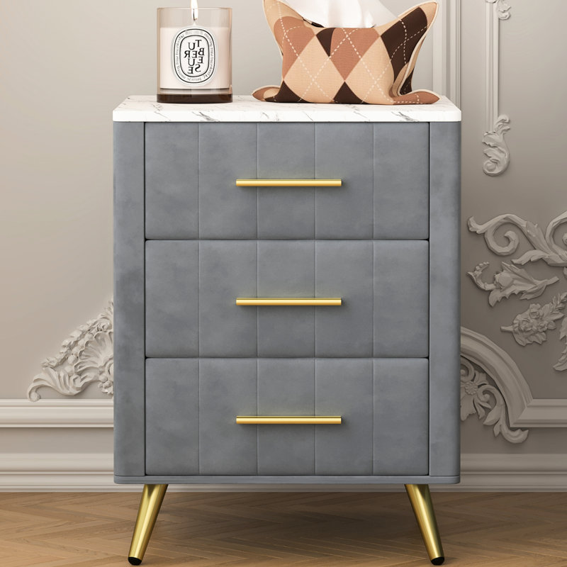 Table de chevet grise rembourrée avec 3 tiroirs, des détails en métal et un plan de travail élégant - idéale pour les pieds de table de chevet de style chambre à coucher, une solution pratique et élégante