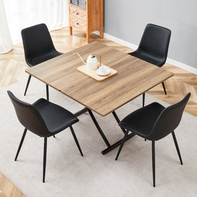 Ensemble de table et de chaises. Plateforme de levage multifonctionnelle moderne, plateau en panneau de fibres à densité moyenne avec autocollant en grain de bois naturel, pieds en métal noir, jumelé à 4 chaises en polyuréthane artificiel noir avec coussins arrondis.