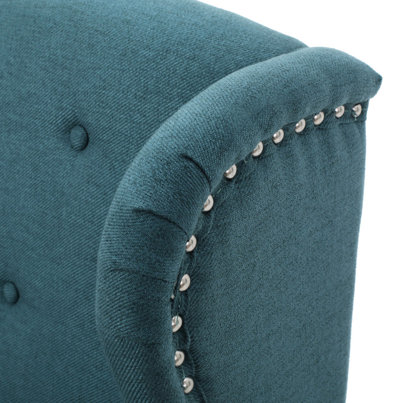 Fauteuil à oreilles avec dossier en tissu bleu sarcelle et boutons cloutés