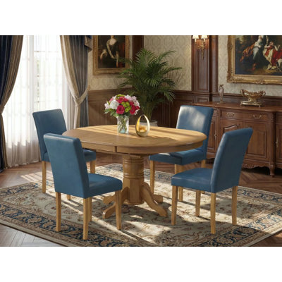 Cet ensemble de salle à manger 5 pièces comprend une table de salle à manger ovale avec feuille papillon et 4 chaises Parson revêtues de similicuir bleu Oasis, 42 x 60 pouces, chêne