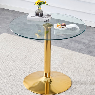 Un plateau en verre de 35 pouces de diamètre et une table ronde moderne et minimaliste avec des pieds en métal doré.