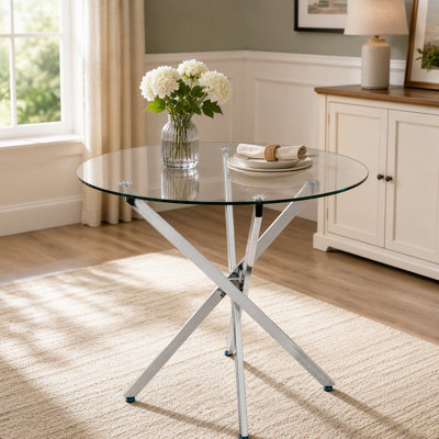Table ronde moderne en verre trempé avec cadre argenté, idéale pour une utilisation polyvalente dans les salles à manger, les salons et les bureaux.