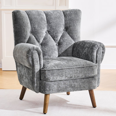 Button-tufted wingback accent chair featuring rolled arms and thickly padded cushions.