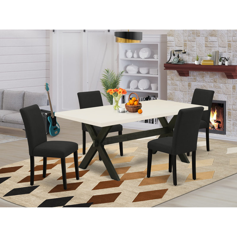 L'ensemble de mobilier de salle à manger 5 pièces comprend une table de salle à manger rectangulaire avec pieds en X et 4 chaises rembourrées en tissu de couleur noire, finition noire brossée