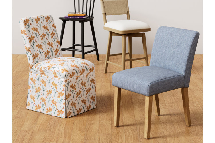 four dining chairs made from different materials: two upholstered and two wood