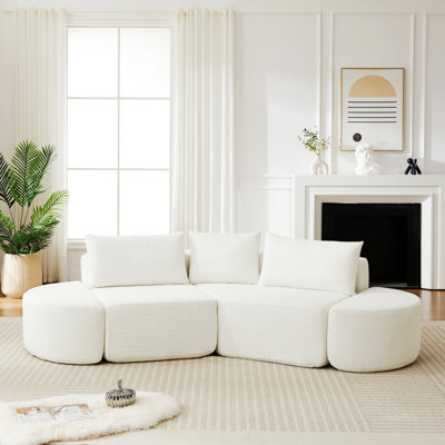 Canapé modulaire avec deux repose-pieds courbés et trois coussins décoratifs