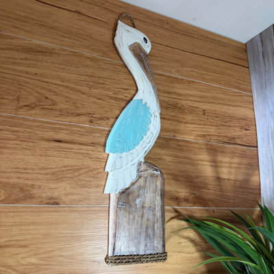 Coastal hand-carved wood pelican wall plaque with aqua wing and rope accent, 24 inches high