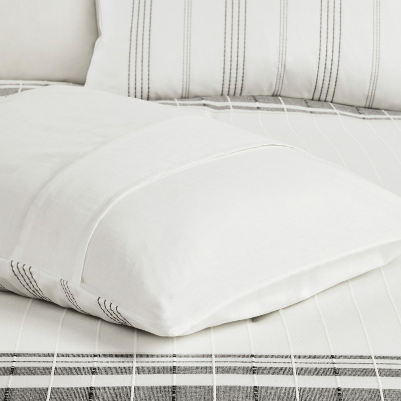 6 édredon en coton double. Rayures grises sur fond blanc. . Édredon trop rembourré. Comprend un édredon, une jupe de lit, des taies décoratives et des oreillers. Literie lavable blanche avec accents. Rayures texturées. Coussins décoratifs à jupe