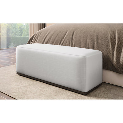 Repose-pieds rembourré élégant et confortable avec base durable, parfait pour la détente et polyvalent dans n'importe quelle pièce.