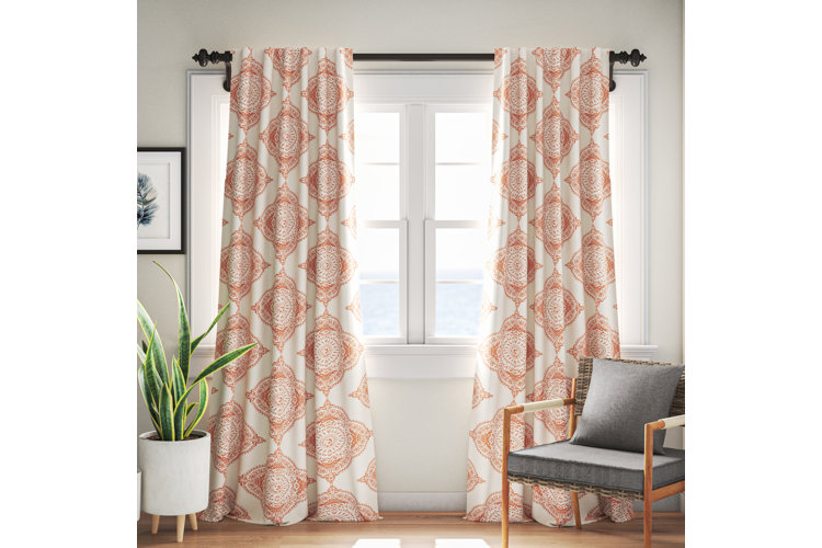 orange and white medallion printed curtains against light beige wall