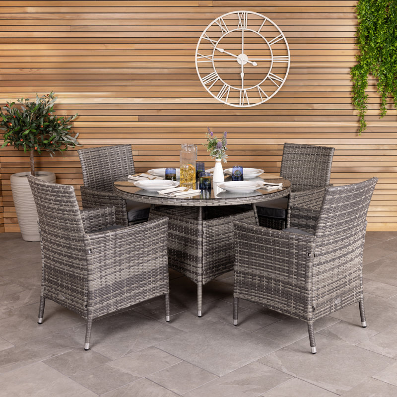 Nohemi 4 - Person Wicker Patio Dining Set with Round Table , Cushions Included, Grey