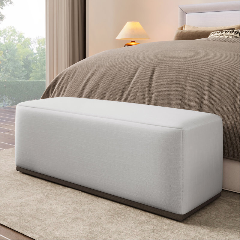 Repose-pieds rembourré élégant et confortable avec base durable, parfait pour la détente et polyvalent dans n'importe quelle pièce.