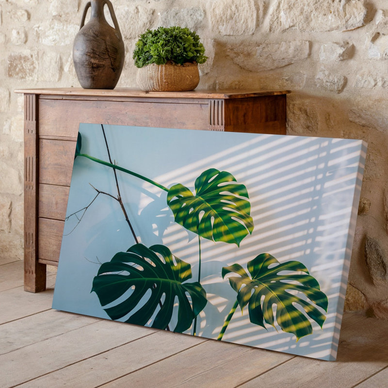 Toile, "Gros plan sur trois feuilles de Monstera vertes vibrantes", art mettant en valeur leurs formes distinctes divisées et perforées