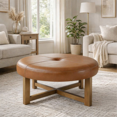 Table basse ronde ottomane en cuir avec base en bois massif, repose-pieds capitonné en similicuir, plateau marron et pieds au fini noyer