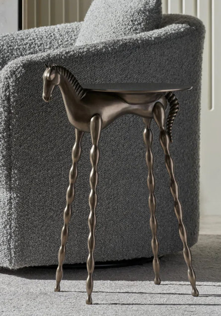 Bronze horse accent table with gray bouclé chair.
