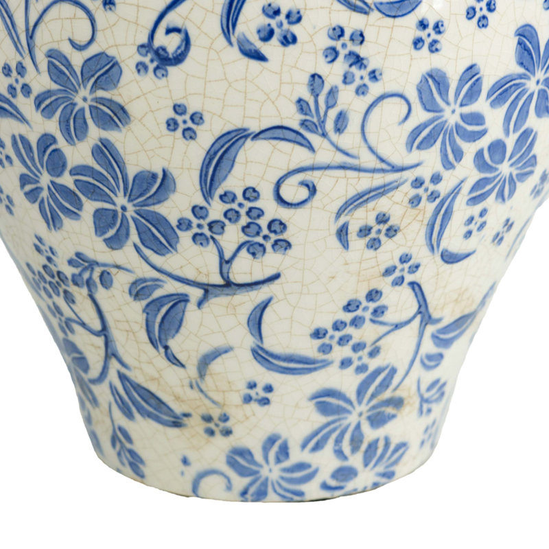 Round Ceramic Vase With Distressed White Finish And Hand-Painted Blue Floral Motif For Timeless Decor And Versatile Display.