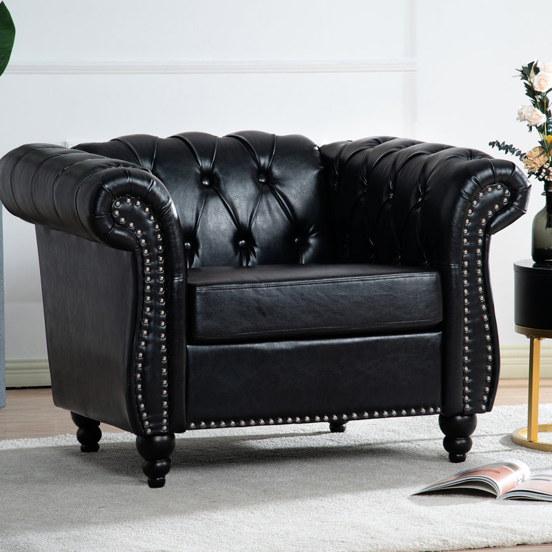 Fauteuil une place au charme intemporel, revêtement en PU souple, pieds en bouleau, hauteur d'assise de 32 cm, largeur des accoudoirs de 22 cm, ambiance harmonieuse, revêtement en PU noir imitation cuir, assise en bois de 57 cm, hauteur de dossier de 49 cm.