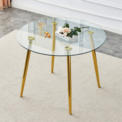 Un plateau de table en verre d'un diamètre de 40 pouces et une table de salle à manger circulaire minimaliste moderne avec des pieds en métal plaqué or