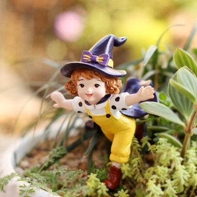 Adorable petite sorcière en résine, figurine d'Halloween à planter dans un pot de fleurs extérieur, avec chapeau violet et salopette jaune. Décoration en résine avec chapeau violet et vol.
