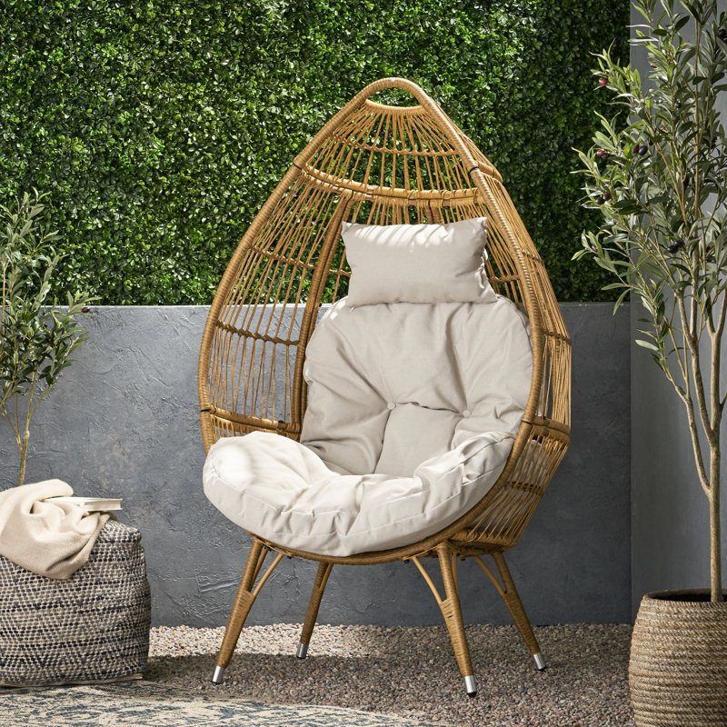 Fauteuil de panier en forme de larme, élégant et confortable, fini beige, idéal pour les espaces extérieurs, coussins inclus.
