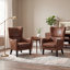 Fauteuil à oreilles en similicuir vieilli avec garniture cloutée