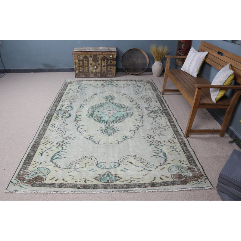 Découvrez un élégant tapis turc rétro à motifs floraux vert et beige pastel pour un décor de salon bohémien