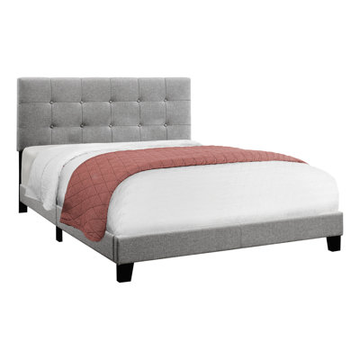 Grand lit tapissier gris pour un environnement de chambre à coucher serein avec cadre et rembourrage en mousse confortable