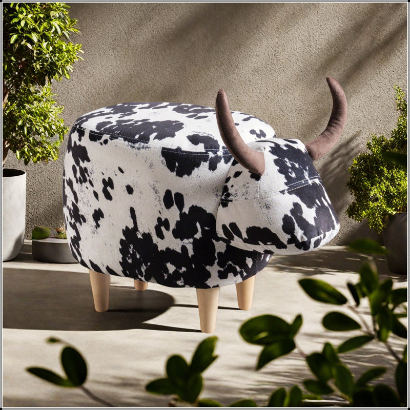 Charmant repose-pieds en forme de vache, tabouret d'appoint moderne avec des cornes de velours et des pieds en bouleau pour une décoration polyvalente