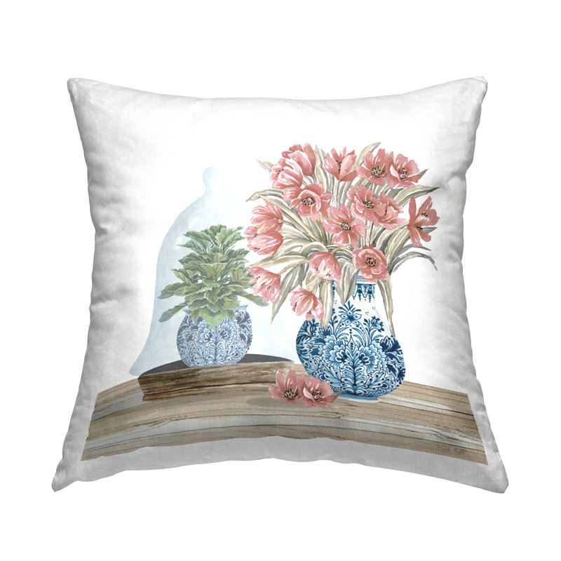 Coussin rose avec motif floral dans un vase