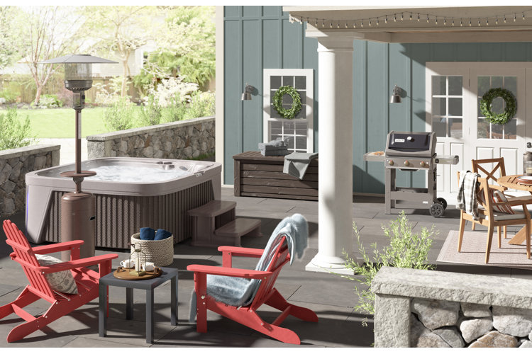 Outdoor patio with a hot tub, a pair of red adirondack chairs, and covered dining area.