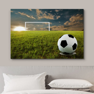 Ballon de soccer noir et blanc sur un terrain au coucher du soleil, photographie de sport, art moderne, urbain contemporain