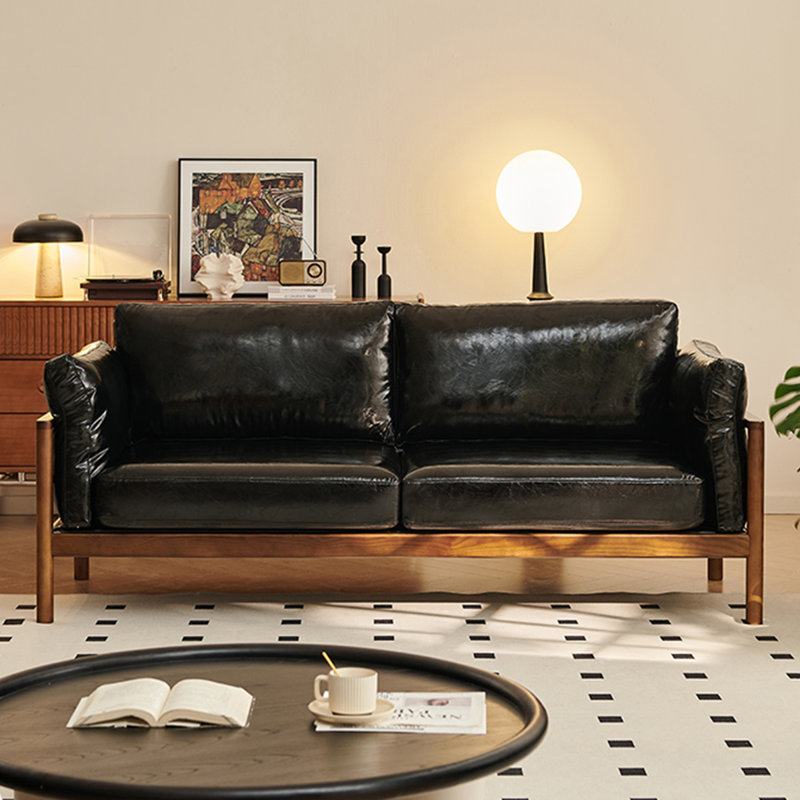 Un canapé double en cuir noir avec coussins, H 32,68 po x l 66,93 po x P 32,68 po