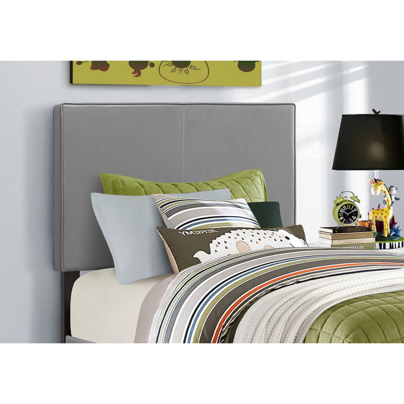 Lit simple avec revêtement en similicuir gris et lit pratique en similicuir, ajoutant une touche de classe aux chambres
