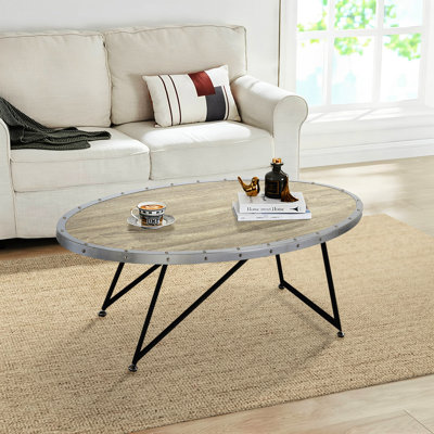 Table basse ovale de style industriel avec dessus en chêne gris vieilli et structure en métal noir, idéale pour la décoration du salon.