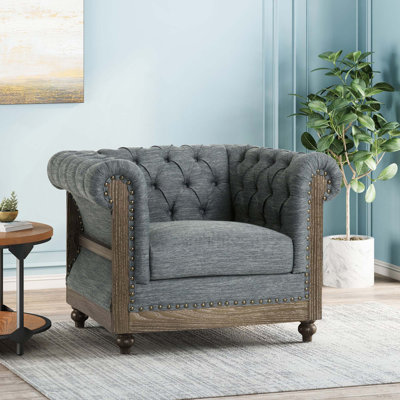 Élégant fauteuil club rembourré capitonné avec accoudoirs roulés pour le salon