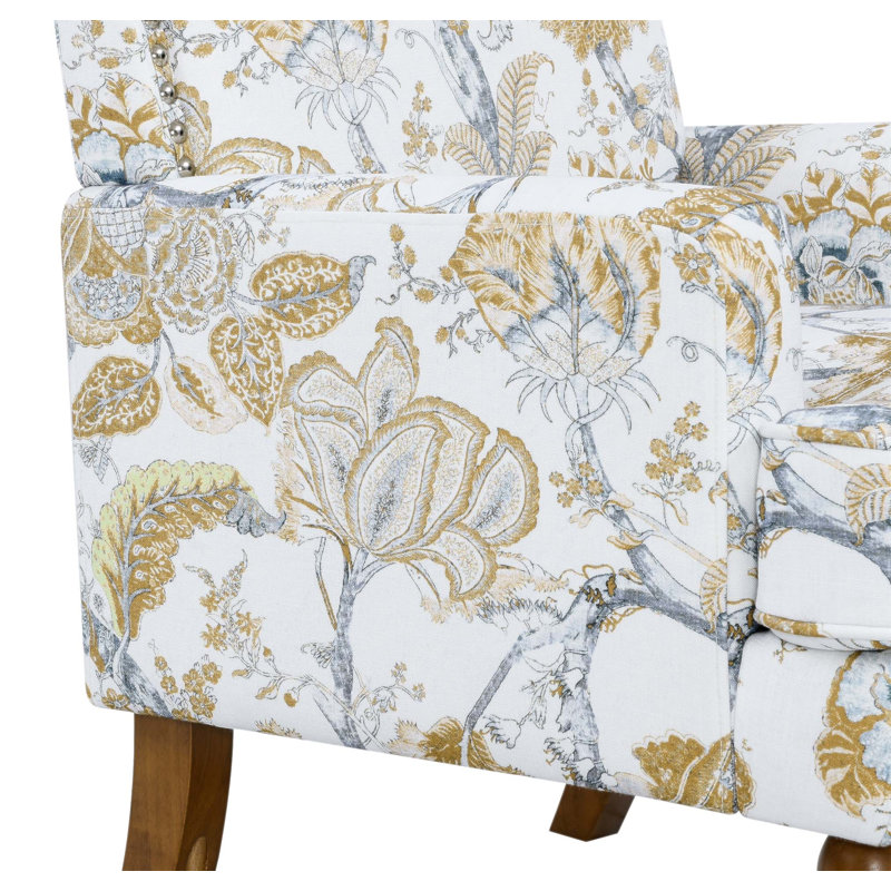 Chic fauteuil floral avec garniture cloutée, imprimé doré et gris, pieds en bois massif, idéal pour les décors campagnards et transitionnels