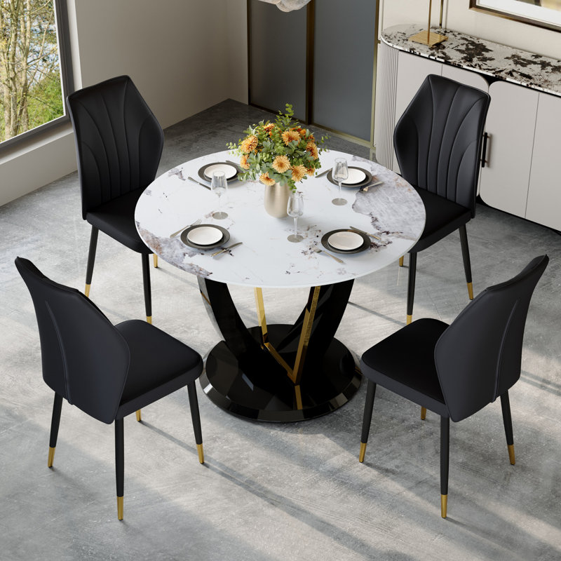 Ensemble de table et de chaises.Une table de salle à manger ronde en verre trempé Pandora de 42 po de diamètre avec pieds en panneau de fibres à densité moyenne en forme de V. Elle est dotée de 4 chaises en polyuréthane noir avec un dossier élargi.