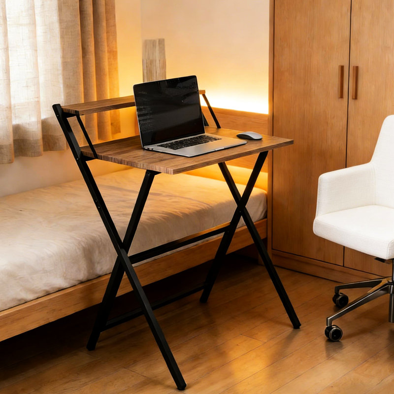 Bureau pliant compact avec tablette pour écran, idéal pour les petites pièces. Finition noyer. Structure en acier en forme de X et installation facile.