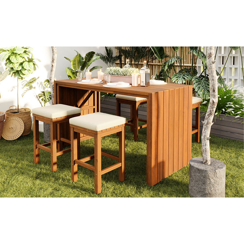 Bar de terrasse extérieur en bois naturel avec quatre tabourets beiges rembourrés, idéal pour se détendre au bord de la piscine. Cinq coussins amovibles pour recevoir.