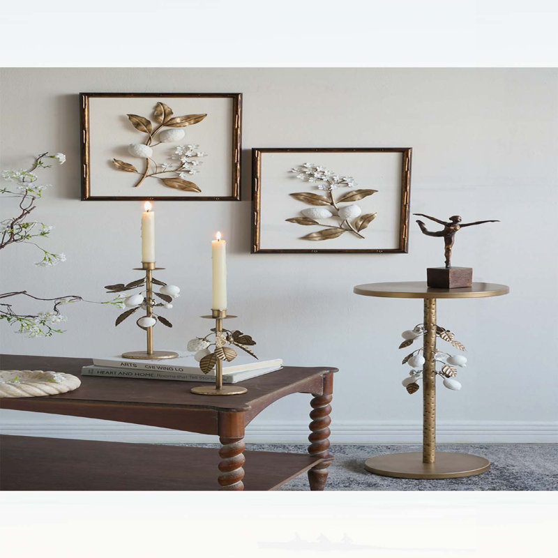 Luxueuse table d'appoint ronde en fer avec accents floraux dorés et blancs, base en ciment robuste pour une décoration intérieure élégante