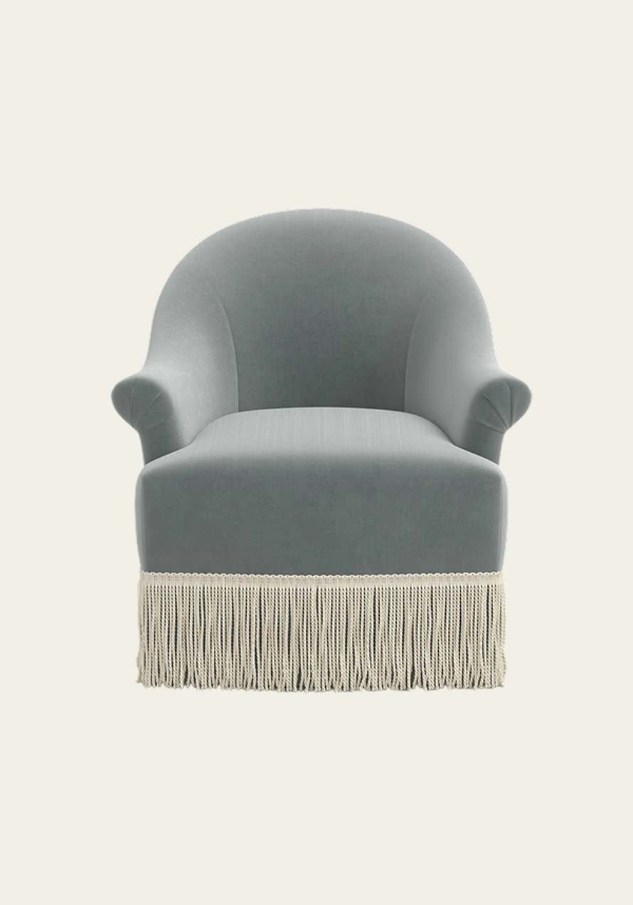 Gray barrel armchair with fringe trim.