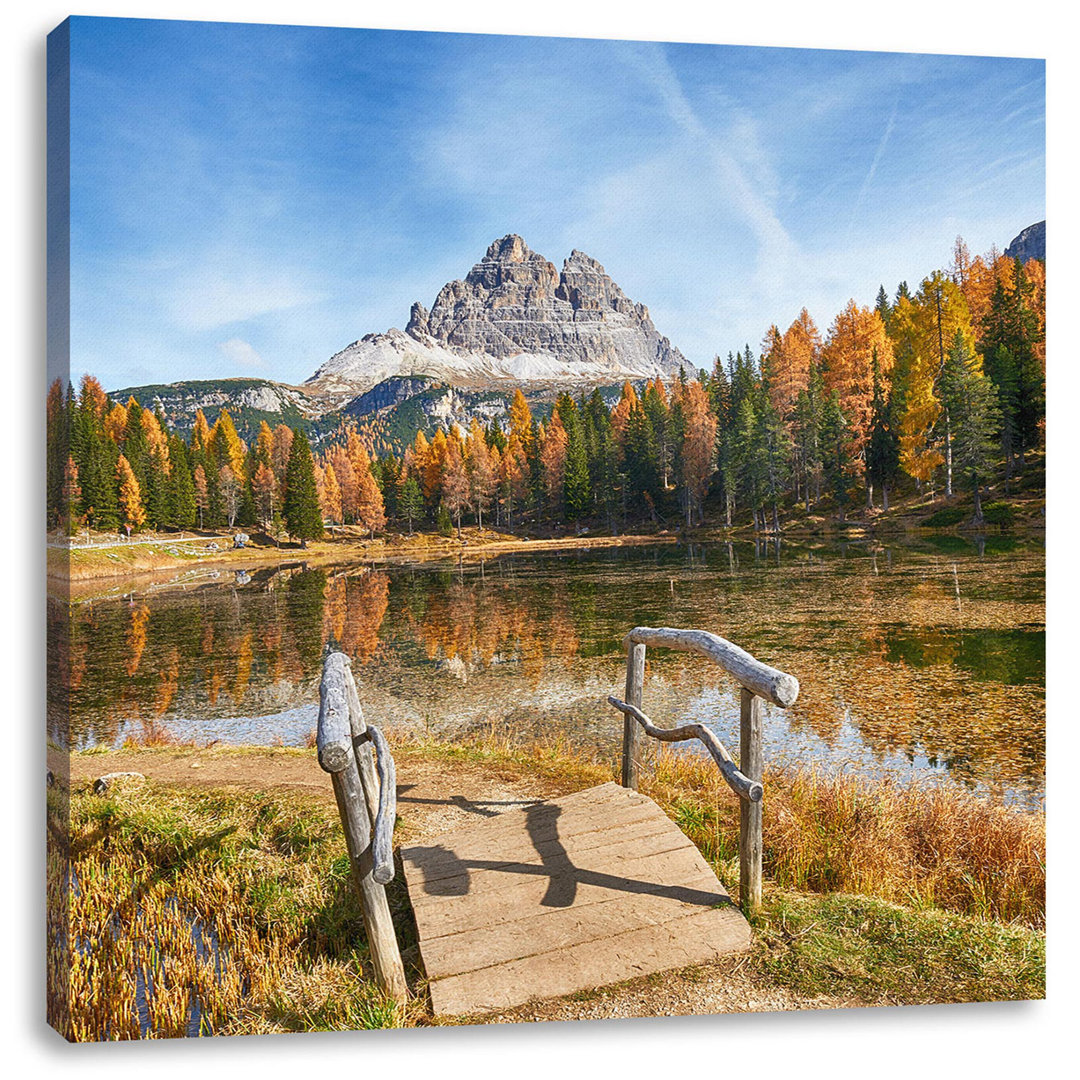 Leinwandbild Holzbrücke am Dolomitensee im Herbst