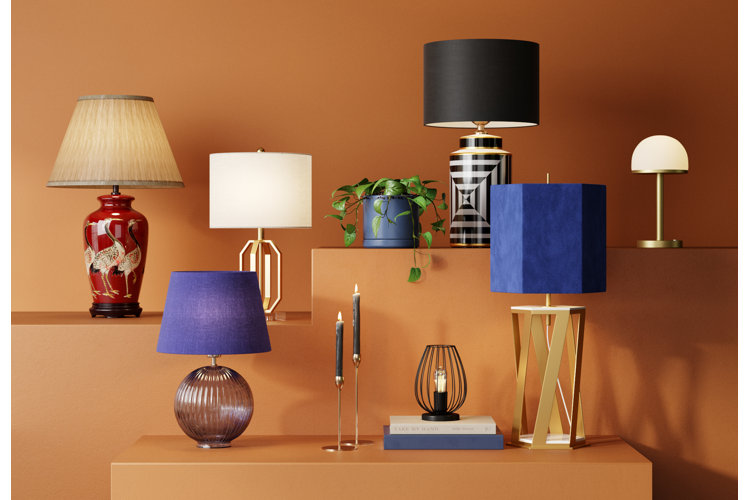 A display of seven different lamp styles placed against an orange backdrop.