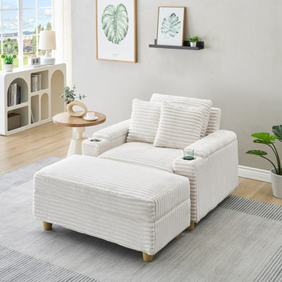 Canapé blanc simple en velours côtelé avec un coussin, deux coussins décoratifs, un repose-pieds et deux espaces de rangement.