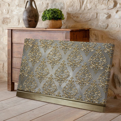 La toile crée un design de papier peint élégant avec un motif damassé complexe en or chatoyant contre un taupe doux