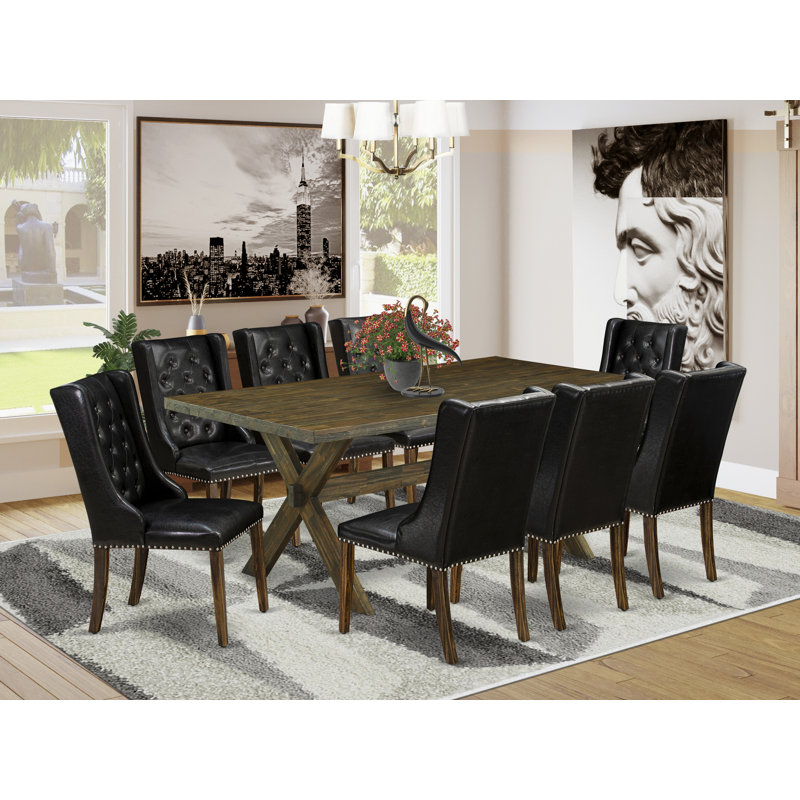 L'ensemble de table de salle à manger 9 pièces comprend une table de salle à manger rectangulaire avec des pieds en X et 8 chaises Parsons en similicuir noir patiné