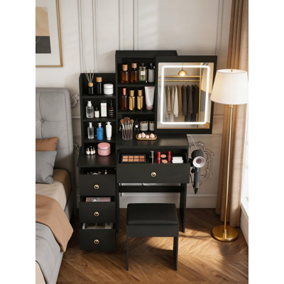 A Modern, Understated Luxury Black Vanity Table With Three Levels Of LED Lighting, Drawers And Open Storage, And A Built-In Power Outlet And Vanity Chair.