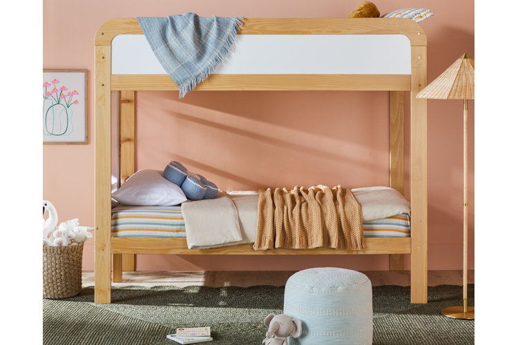 Eclectic wood bunk beds in a child's bedroom. A range of plush toys and colorful bedding