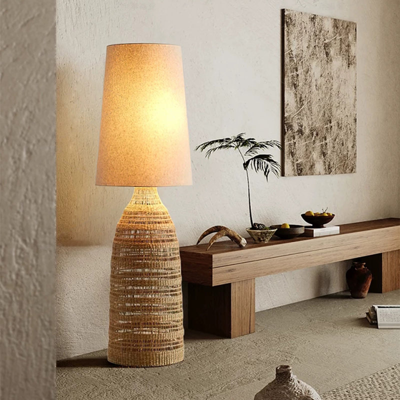 Le salon est orné d'une lampe sur pied en rotin et en lin, avec un abat-jour
