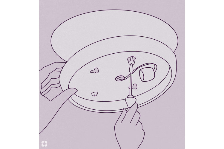 A person's hands removing and unscrewing a light fixture from the mounting base on the ceiling.